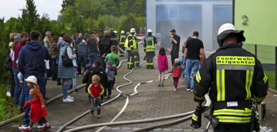 Aus der Halle quillt Rauch, in der Mitte Kommandant Sascha Eichkorn, der die Übung am Mikrofon erklärt. Foto: Hella Schimkat